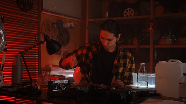 istock Analog Photography Darkroom Process with Red Lighting Ambiance 2215590111