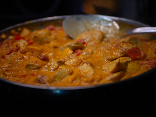Cooking a traditional curry in a stainless steel pan