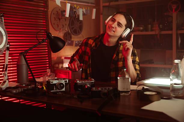 istock Young Man Enjoying Music in a Creative Red-Toned Studio 2215594742