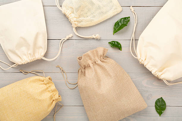 istock Small eco sacks on wooden background, top view 2215594831
