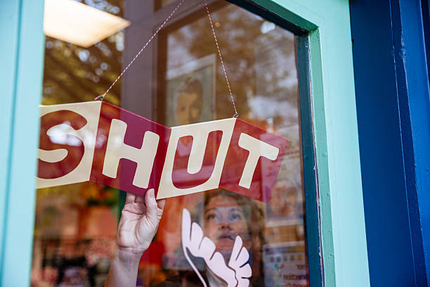 istock Small Business Owner Closing Shop Sign 2215595656