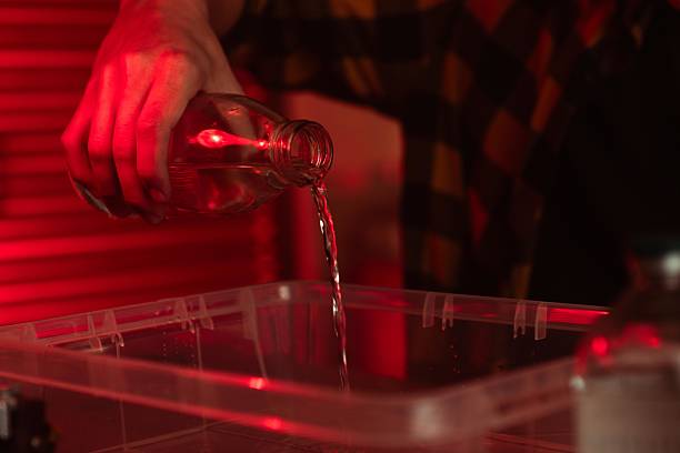 istock Pouring Liquid from Glass Bottle with Red Background Light 2215596698