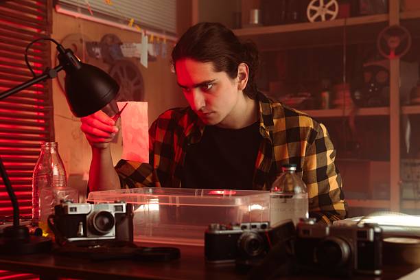 istock Young Photographer Developing Film In Darkroom Setting 2215597148