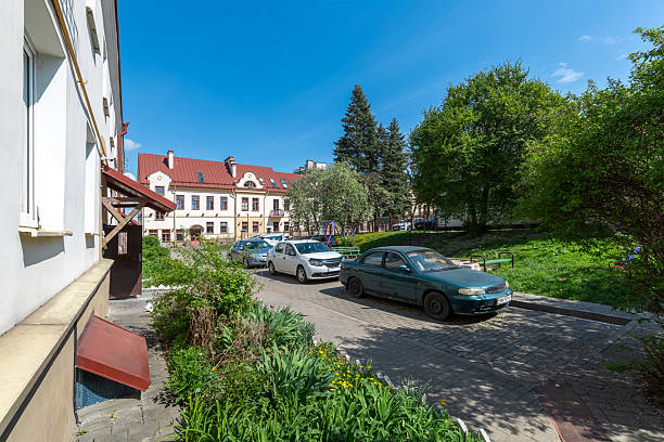 istock Pastel Facade Courtyard with Parked Cars 2215599983