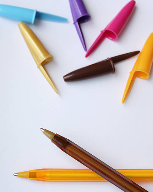 istock Two color ballpoint pens and several pen caps on white background. 2215601464