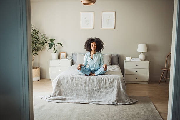 istock Relaxed black woman meditating during morning on a bed 2215601521