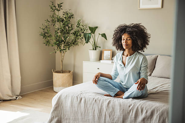 istock Relaxed black woman meditating during morning on a bed 2215601891