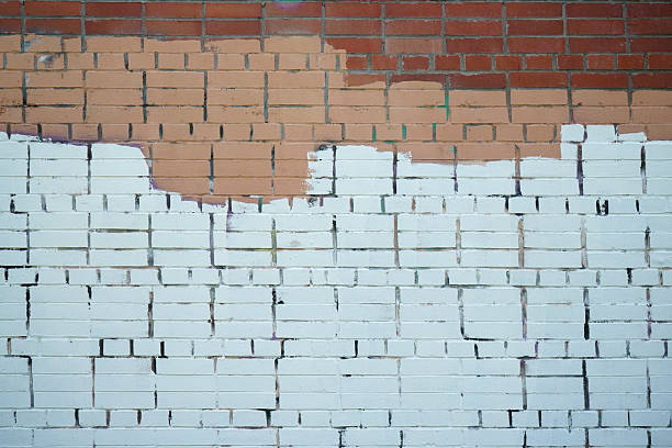 Brick wall painted with stripes of paint.