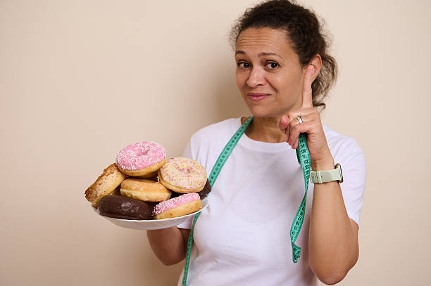 istock Reflecting on Balance Between Indulgence with Doughnuts and Healthy Choices 2215610591
