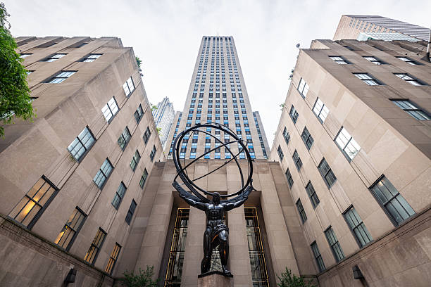 Low-angle view of Rockefeller Center in Midtown Manhattan, New York City. This striking perspective highlights the towering Art Deco architecture and grandeur of one of the city's most iconic landmarks, capturing the vertical majesty and timeless elegance of this historic building complex.