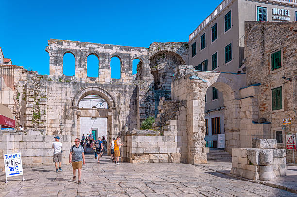 Stone building facades and clock tower in Narodni Trg, Split, Croatia