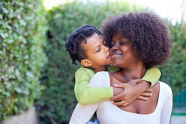 istock Spring portrait African mother embracing her child in backyard 2215613094