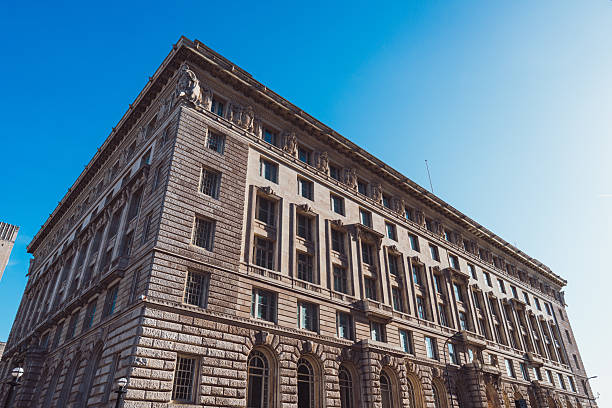 Low angle view of ornate stone buildings in antwerp, belgium, showcasing intricate architectural details against a bright blue sky