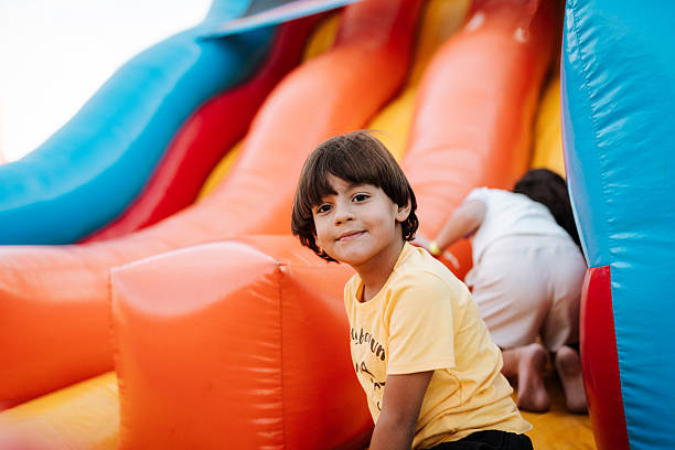 istock Girl and boy playing in inflatable playground 2215620241