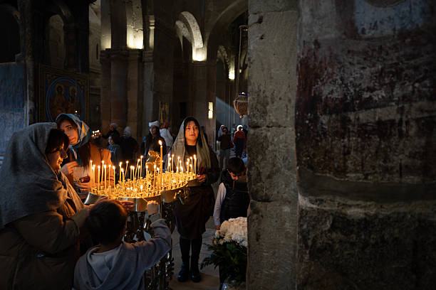 Jerusalem, Israel - May 15, 2018: Monks taking part in a procession in the Church of the Holy Sepulchre in the Aedicula, near Jesus's empty tomb, where he was buried and resurrected