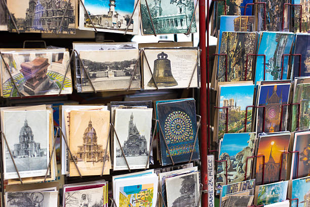 Paris, France: A retail display of vintage postcards at an outdoor antiquarian bookseller (bouquiniste); the Seine River is just off-camera. The postcards show Notre Dame cathedral and various other French landmarks.