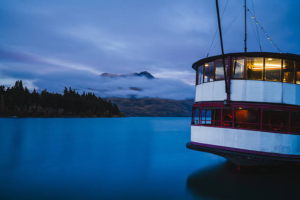 istock Ship drifting with misty peaks in background. 2215628336