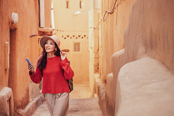 istock Young woman tourist using smartphone while exploring ancient Moroccan city, famous for its earthen architecture 2215629358