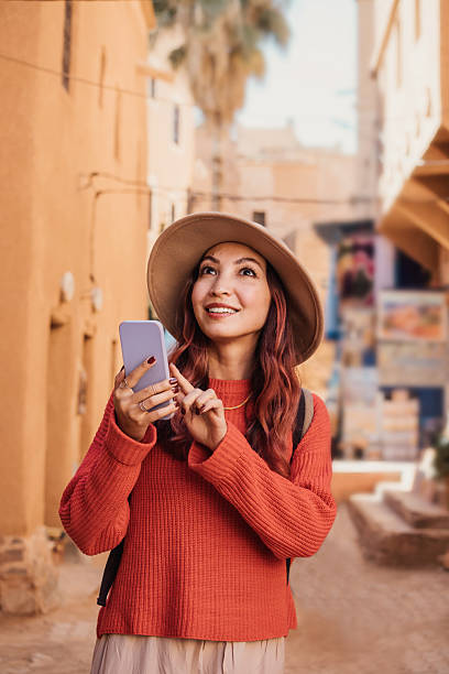 istock Young woman tourist using smartphone app and smiling while visiting Marrakech medina in Morocco 2215629362