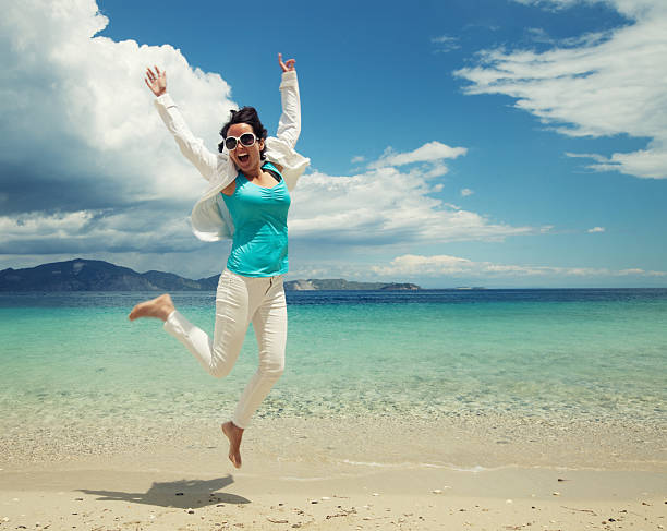 Happy girl jumping on the beach, summer holiday