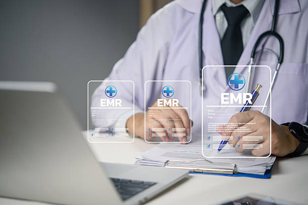 istock Doctor working on EMR system with digital medical data, healthcare technology, electronic records, and telemedicine concept for modern hospital management. 2215640394