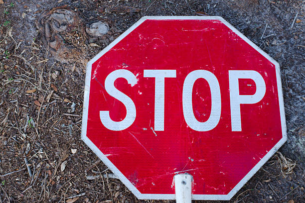 istock Red Stop Sign Lying on a Dirt Ground in Outdoor Environment 2215643045