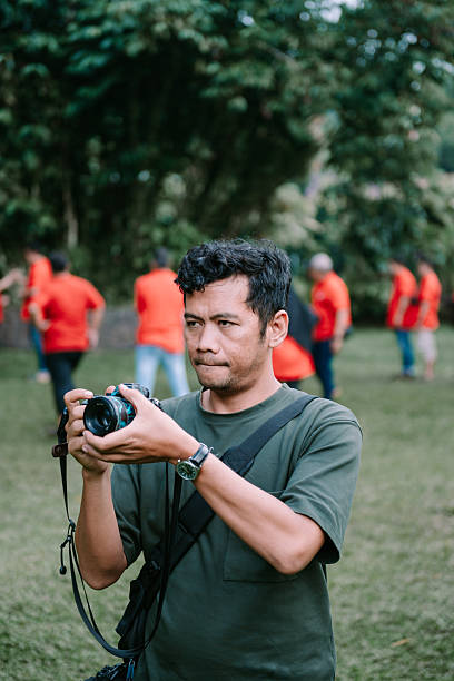 istock Concentrated photographer capturing event moments outdoors with camera 2215643462