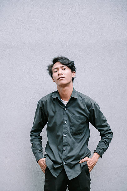 istock Stylish young asian man portrait posing against textured wall backdrop 2215652362