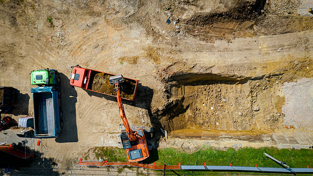 istock Ariel view excavator is loading a truck with ground on building site 2215662271