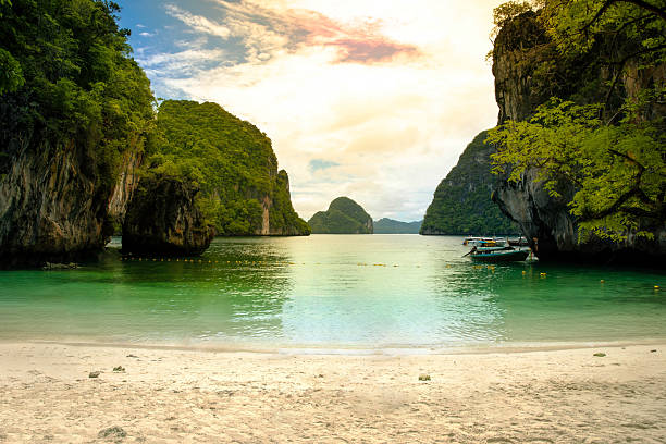 Lading Beach, with its white sand, crystal-clear emerald waters, beautiful limestone cliffs, and lush greenery, is in Krabi, Thailand.