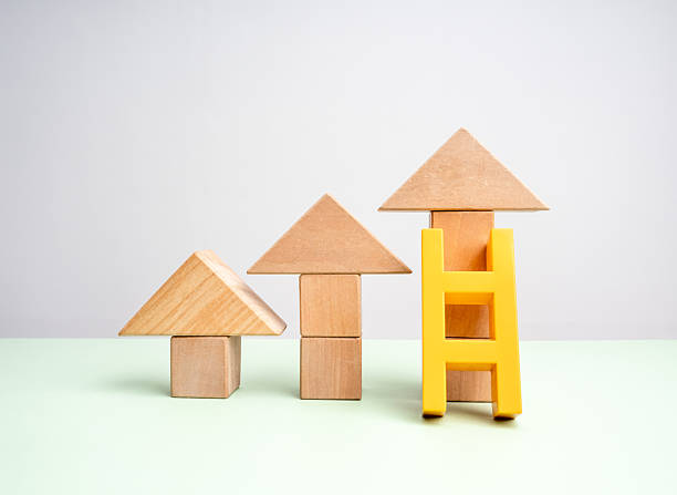 istock Three wooden arrowheads built by cube blocks as bar graph chart steps with yellow ladder on green table, white background. Business growth, Investment, shortcut, economic improvement concepts. 2215668979