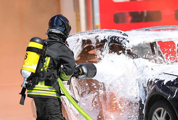 istock Firefighter with helmet and oxygen cylinder while spraying   foam coat to extinguish   car fire 2215669197