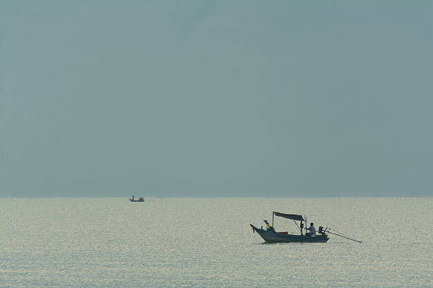 Small Boats in Vast Sea Under Sky