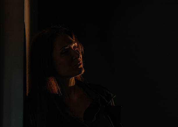 istock Contemplative young caucasian female in dramatic lighting 2215672258