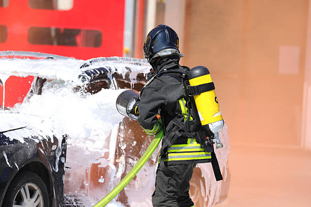 istock Firefighter sprays foaming white on car to put out fire after car accident 2215672565