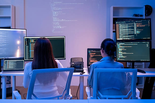 istock young Asian software development manager leads a late-night office discussion with his executive team, mentoring developers and analyzing source code to guide programming and project development 2215674601