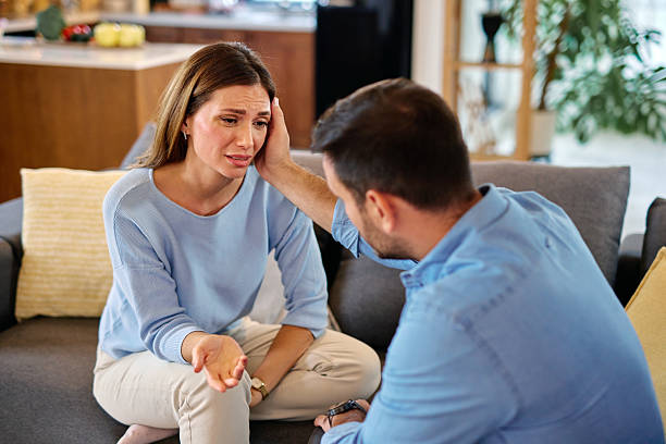 istock Man comforting his sad girlfriend at home on the sofa 2215677716