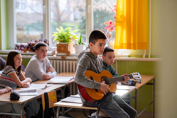 istock The boy plays the guitar in class. 2215678126