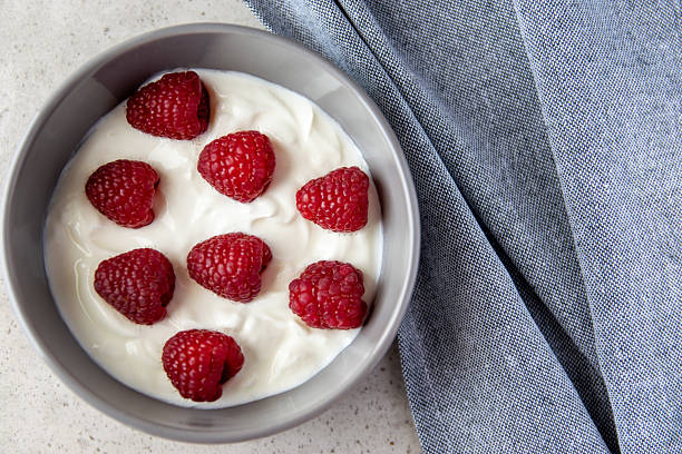 istock Gray bowl and natural yogurt with berries on the stone marble table. 2215678706