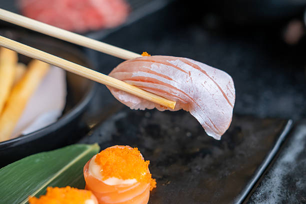 istock Chopsticks holding salmon sushi, in the restaurant 2215681704