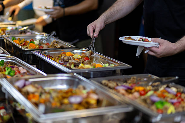 istock Diverse buffet spread with guests serving themselves at a festive gathering 2215690356
