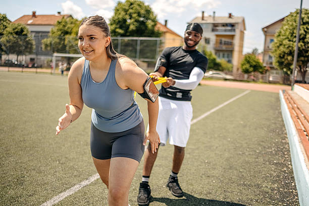 istock People exercising together outdoors using rubber band and assisting each other 2215690759