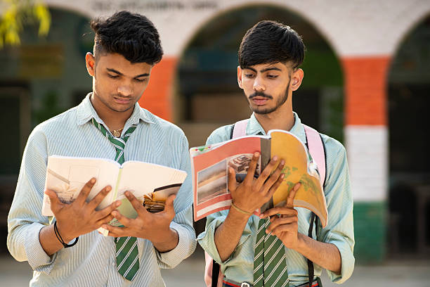 istock Two teenage school students studying on book together and discussing about studying by looking at the book. 2215693963