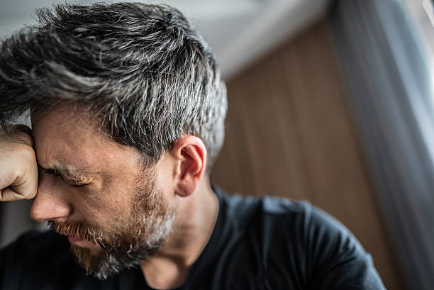Close-up of distressed man expressing intense frustration