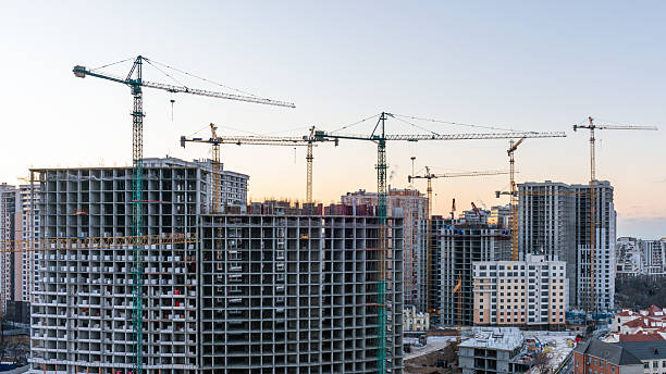istock Construction site, cranes and multi-storey unfinished buildings at sunrise or sunset 2215708340