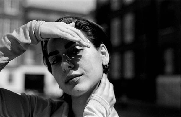 istock Young woman shielding her eyes from sunlight in urban setting 2215711994