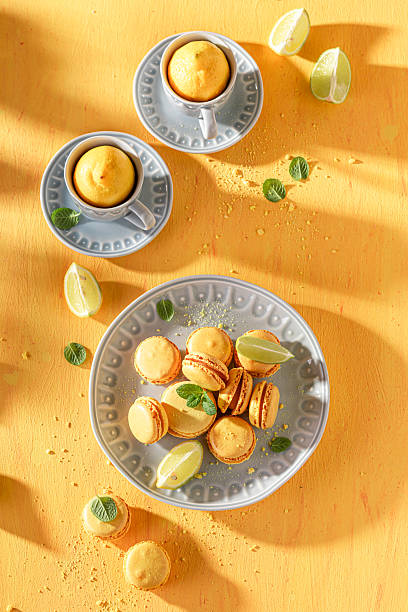istock Delicious and fresh lemon macarons on plate on yellow background. 2215714091