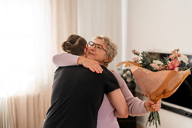 istock Son Hugging His Mother During Mother's Day Celebration with Flowers 2215717670