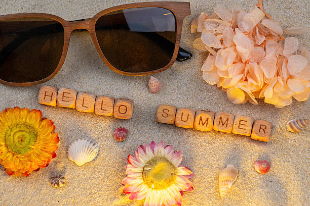 istock Hello summer: sunglasses and flowers on sandy beach with seashells 2215723963