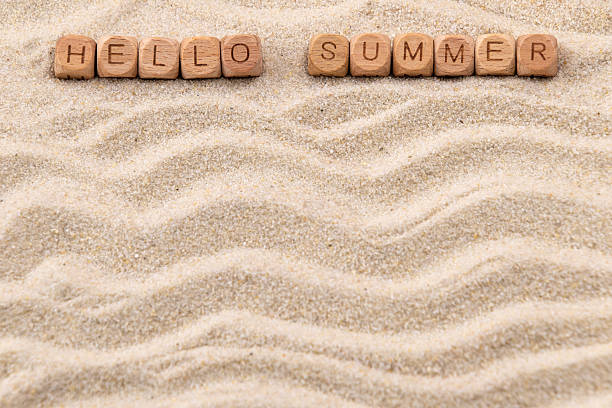 istock Hello summer message on sandy background with wooden blocks 2215723967